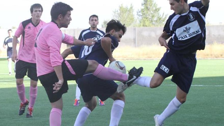 Dos jugadores del GCE Villaralbo luchan por hacerse con el balón ante el capitán del Cristo Atlético.