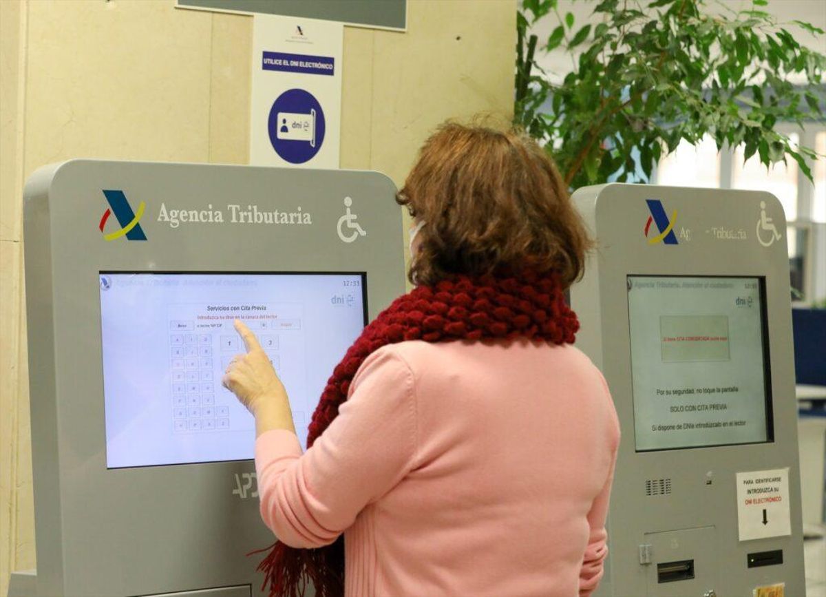 mujer recoge turno en la oficina de la Agencia Tributaria