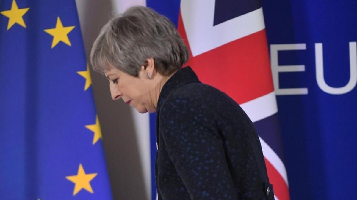 La primera ministra británica, Theresa May, pasa ante las banderas de la UE y del Reino Unido tras celebrar una rueda de prensa en Bruselas.