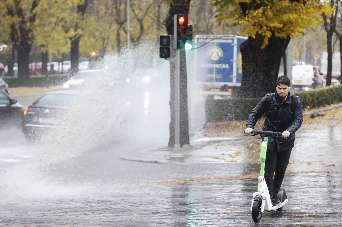 MADRID, 13/12/2022.- Un hombre usa un patinete eléctrico bajo la lluvia este martes en Madrid, que ha activado la fase de preemergencia del plan especial de Protección Civil ante inundaciones INUNCAM ante la previsión de lluvias abundantes. EFE/ Mariscal