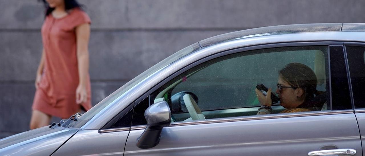 Una mujer habla con el móvil en el coche.