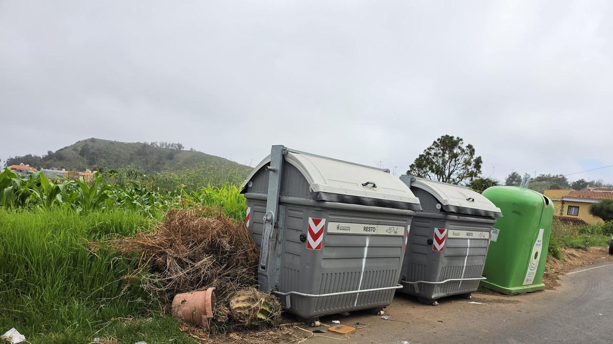 Imagen de contenedores en la calle El Trazo, la principal vía de La Caridad