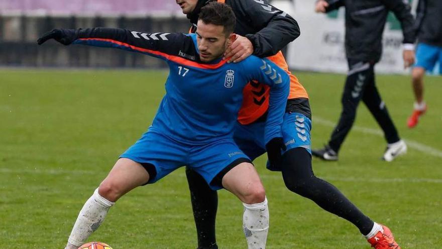 Fernández protege el balón ante Peña en un entrenamiento.