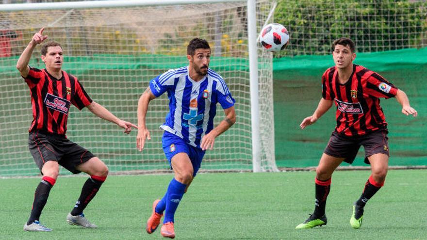 Elvis controla a Villanueva, del Lorca Deportivo, y a la derecha, Mario; durante la eliminatoria de la semifinal de ascenso a Segunda B