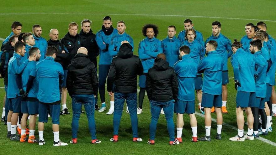 Los jugadores madridistas escuchan la charla de Zidane en el entrenamiento de ayer en París.