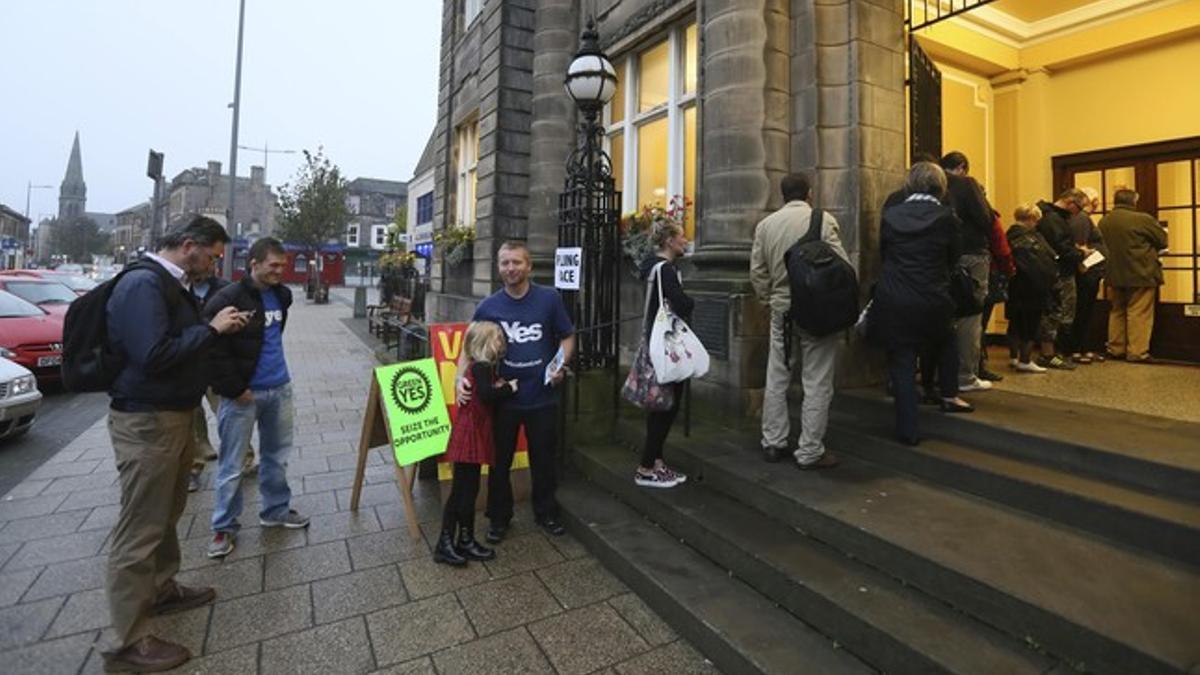 Voters wait for the polling station to open to cast their vote in Portobello near Edinburgh, Scotland