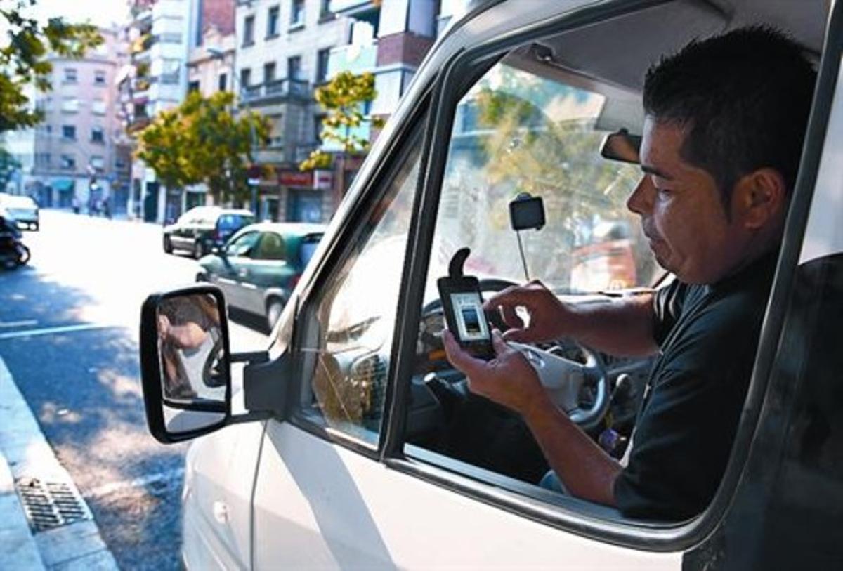 Un conductor utilitza la nova forma de pagament de la zona blava a través del mòbil, ahir, al Guinardó. Un conductor utilitza la nova forma de pagament de la zona blava a través del mòbil, ahir, al Guinardó.