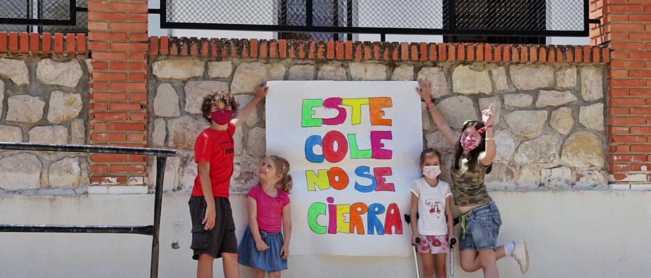 Algunos de los alumnos del centro rural, con una pancarta a la entrada del colegio. A la derecha, una de las aulas de la escuela de Millares | LEVANTE-EMV