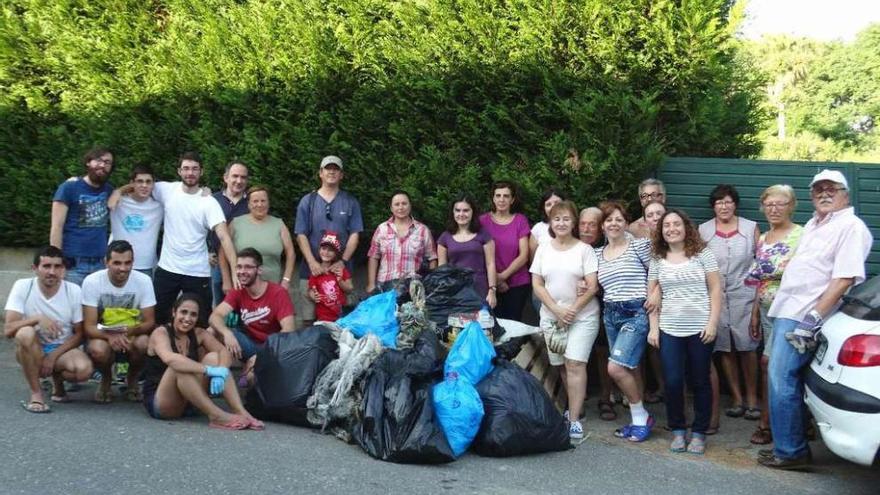 Los vecinos participantes en las tareas de limpieza de la playa. // FdV