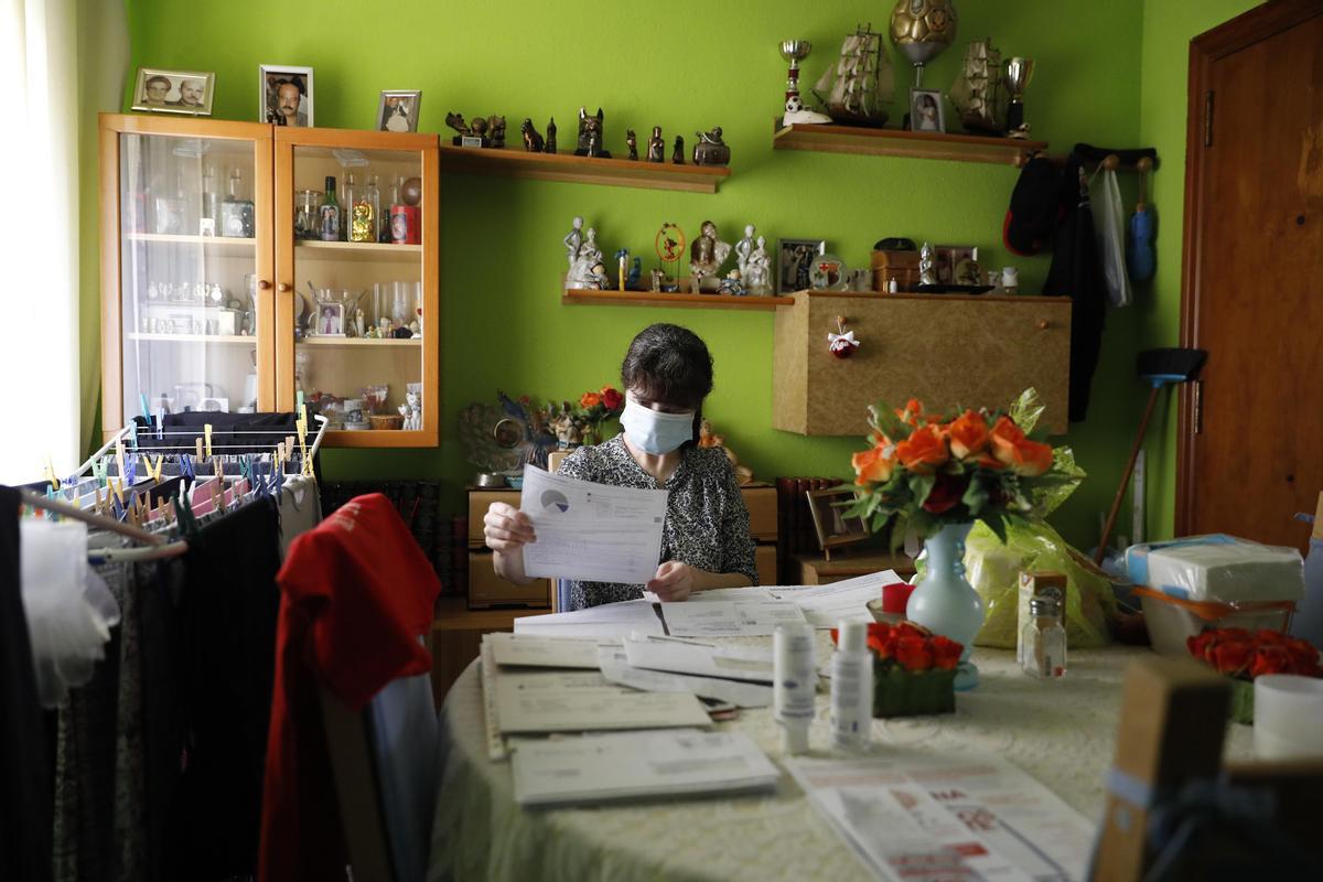 Una mujer revisa las facturas de la luz, agua y gas.