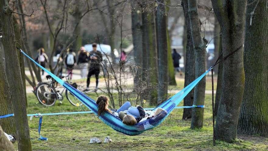 Tres niñas descansan, ayer, sobre una hamaca en un parque de Berlín. // Reuters