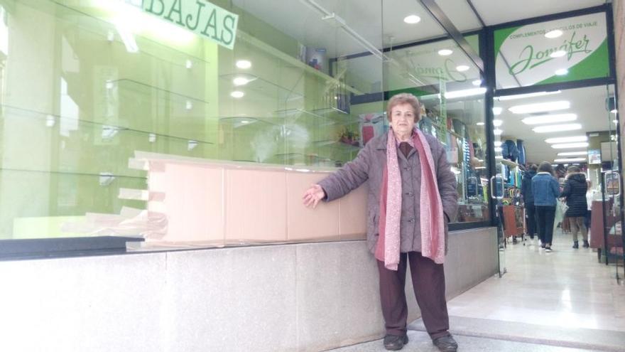 Antonina López, dueña del establecimiento, muestra el escaparate roto.