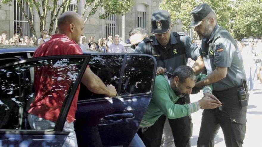 El acusado del doble crimen sale del coche camuflado de la Guardia Civil a la fuerza a su llegada al juzgado, en medio de los insultos del público congregado ante el edificio.