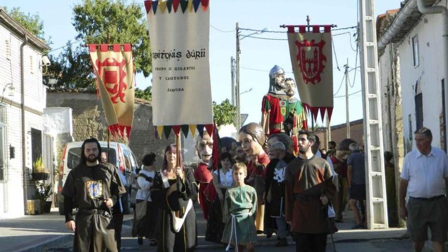 Gigantes y cabezudos marchan por una calle de Entrala.