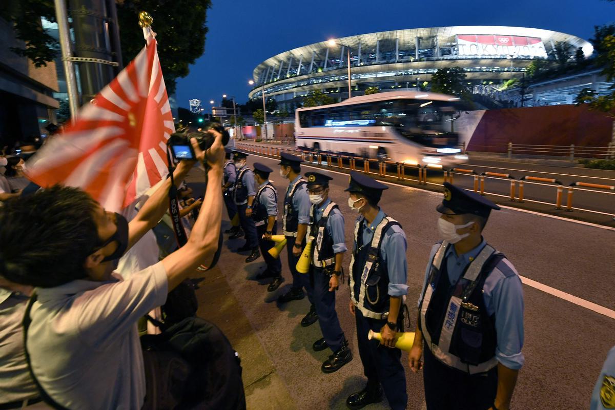 Oficiales de policía controlan a los fans olímpicos, en el exterior del estadio olímpico de Tokyo.