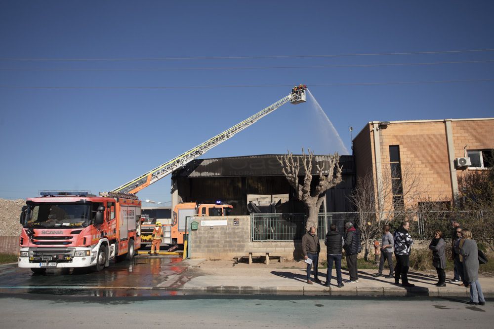 Los bomberos siguen trabajando en la nave del Port de Sagunt un día después del incendio