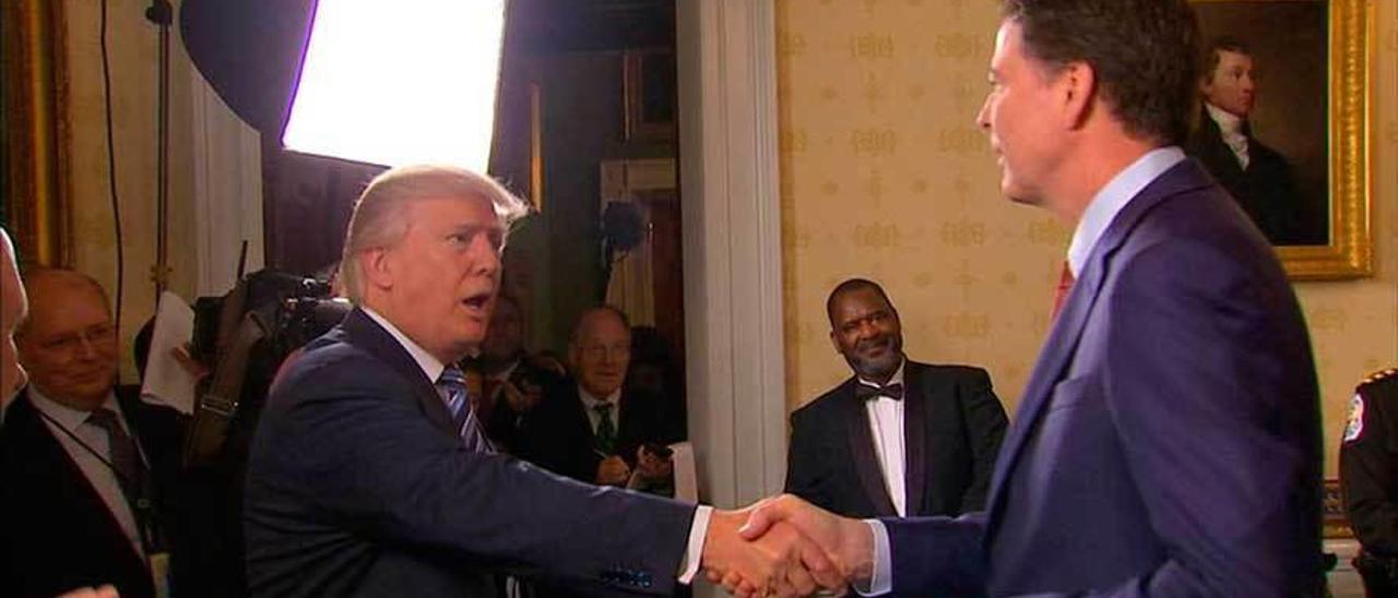 Trump estrecha la mano de James Comey.