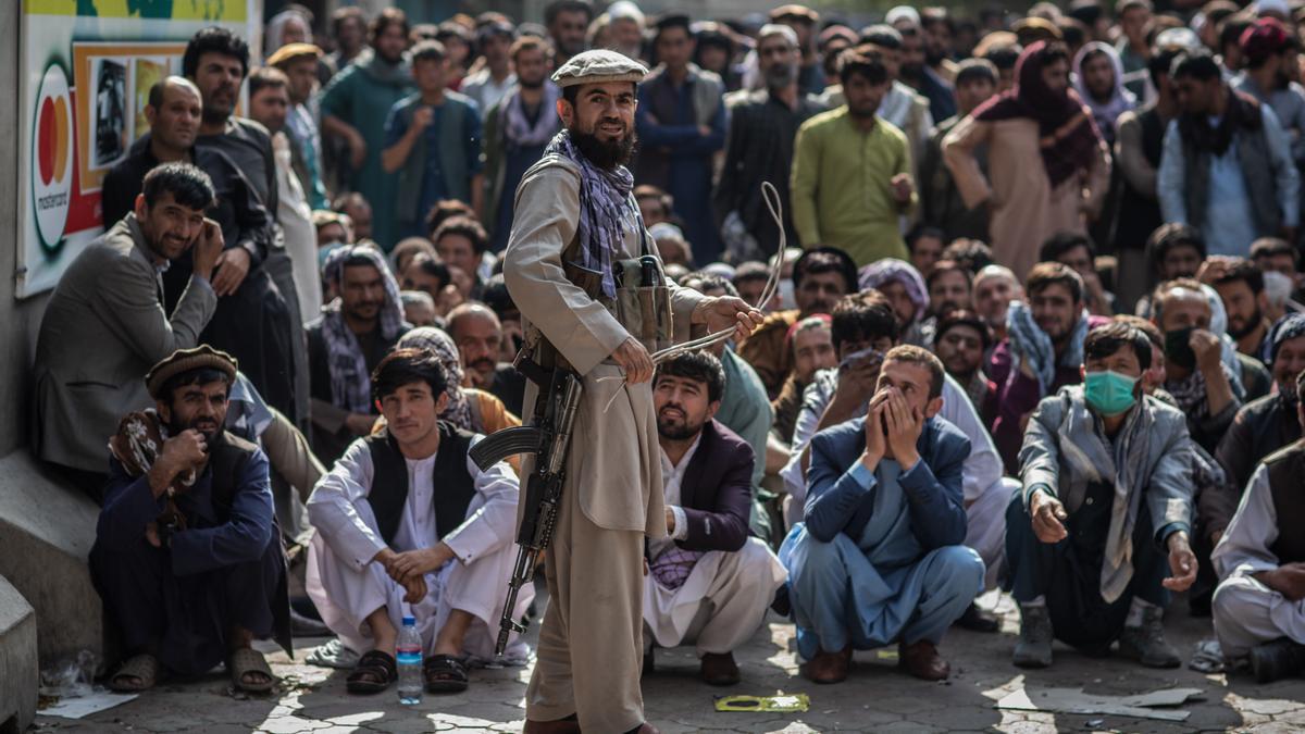 Un miliciano talibán guarda la cola para retirar dinero en Kabul, Afganistán.