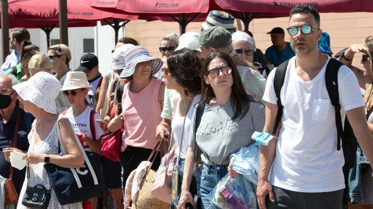 Turistas llegados en crucero esperando un taxi en Ibiza.