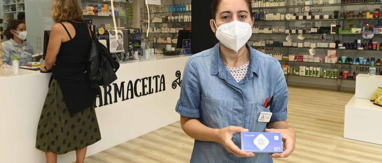 Una farmacéutica muestra un test de gripe y COVID, ayer en una farmacia de Vigo. |   // PABLO HERNÁNDEZ GAMARRA