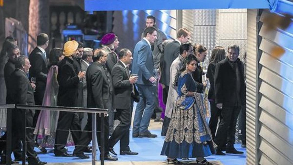 Shristi Mittal (mirando a cámara) y su prometido, Gulraj Behl (detrás), ayer a su llegada al pabellón de Italia en Montjuïc. Debajo, el 'show' de doma.