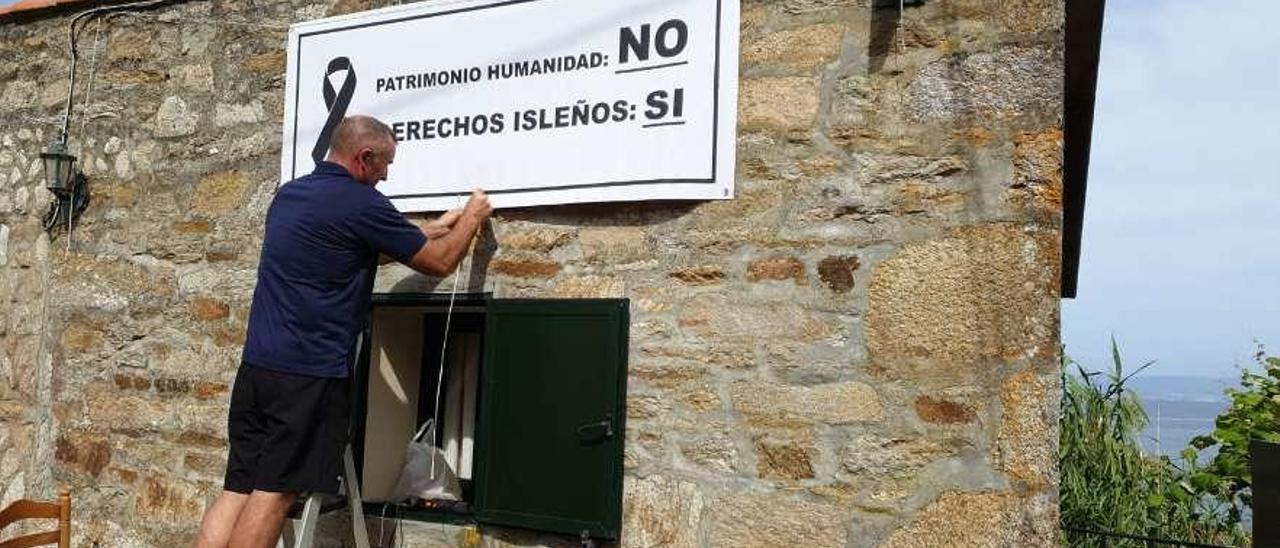 Un vecino coloca un cartel de protesta para reivindicar el acceso libre en Ons. // FdV