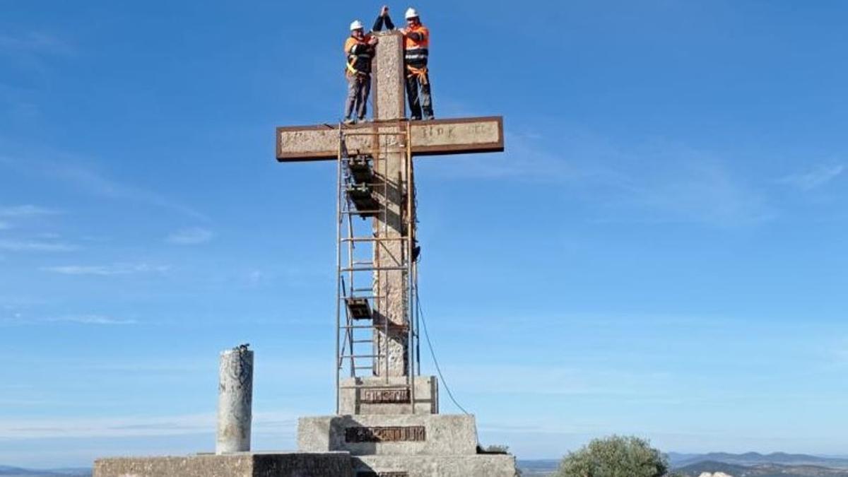 Dos operarios trabajan en la parte superior de la Cruz del Peñón.