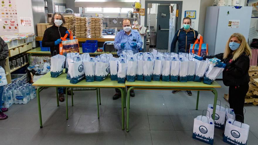 Uno de los colegios que sirven como punto de recogida de estos menús, en cuya entrega participan voluntarios y personal municipal.