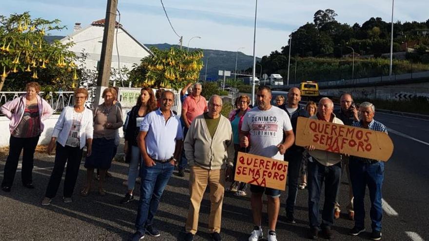 Los vecinos de Chapela, esta mañana, concentrados en la N-552 en la zona de Angorén. / FdV