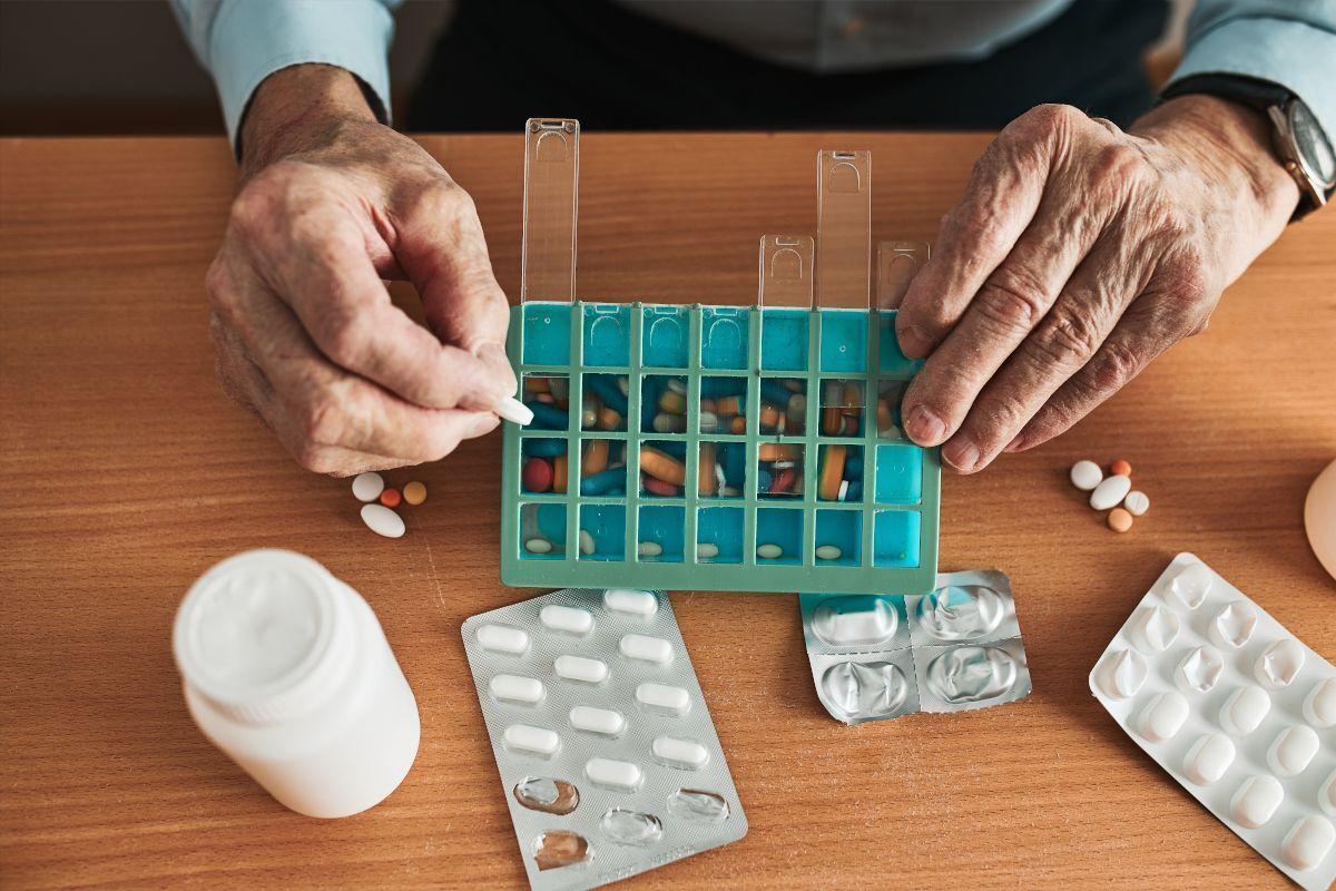 Un hombre mayor organiza sus medicamentos. Imagen de recurso.