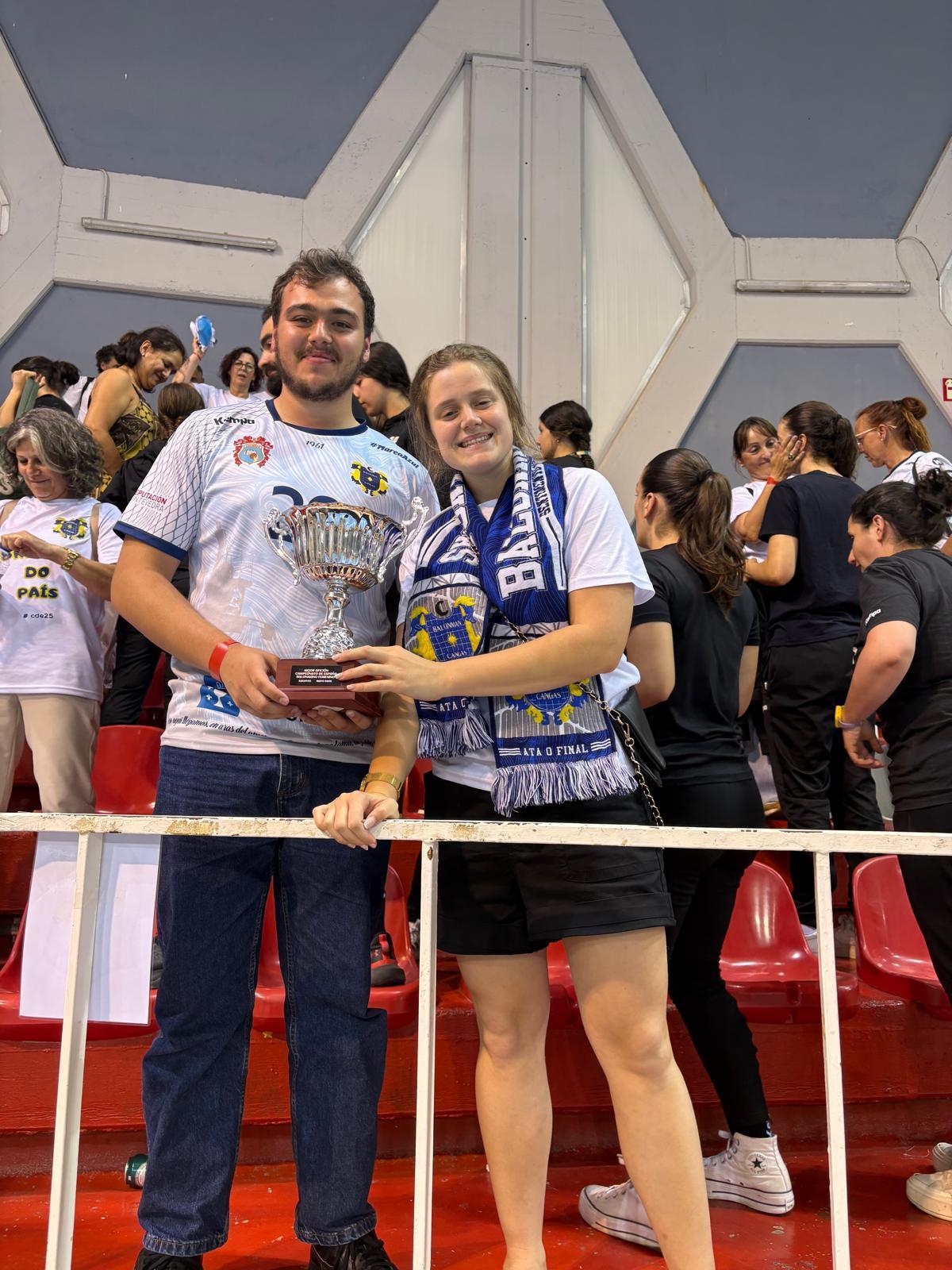 Dos de los integrantes de la expedición canguesa con el premio a la mejor afición del torneo.