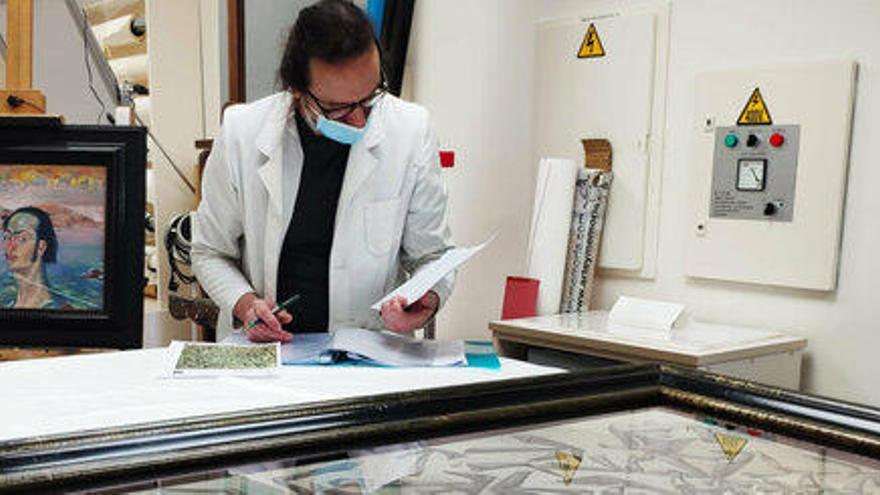 Pla de general d'un restaurador comprovant una de les obres de Salvador Dalí que es deixaran en préstac per una exposició a Itàlia el 30 d'abril de 2021