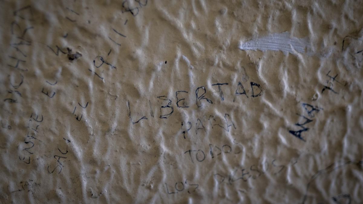 Inscripciones a bolígrafo en la pared de una celda.