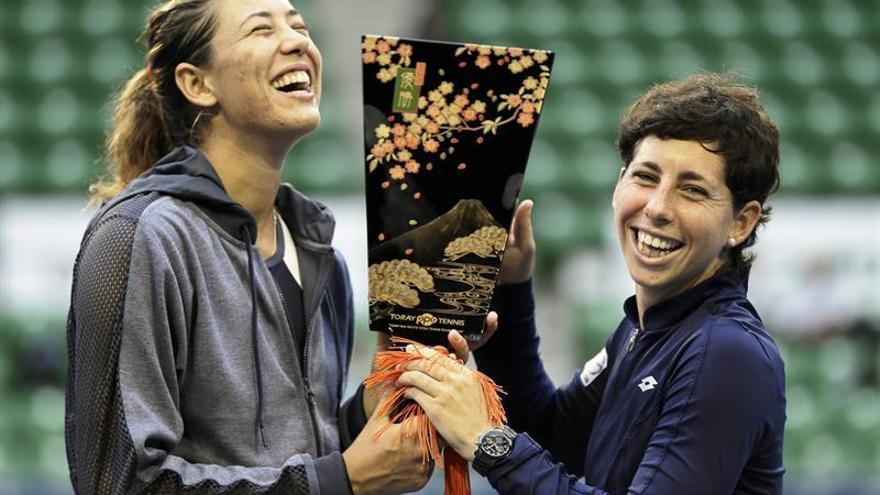 Las tenistas Carla Suarez Navarro (dcha)  y Garbine Muguruza posan con su trofeo tras ganar la final de dobles contra las taiwanesas Chan Hao-Ching y Chan Yung-Jan en el torneo de Tokio en Japón este 26 de septiembre de 2015.