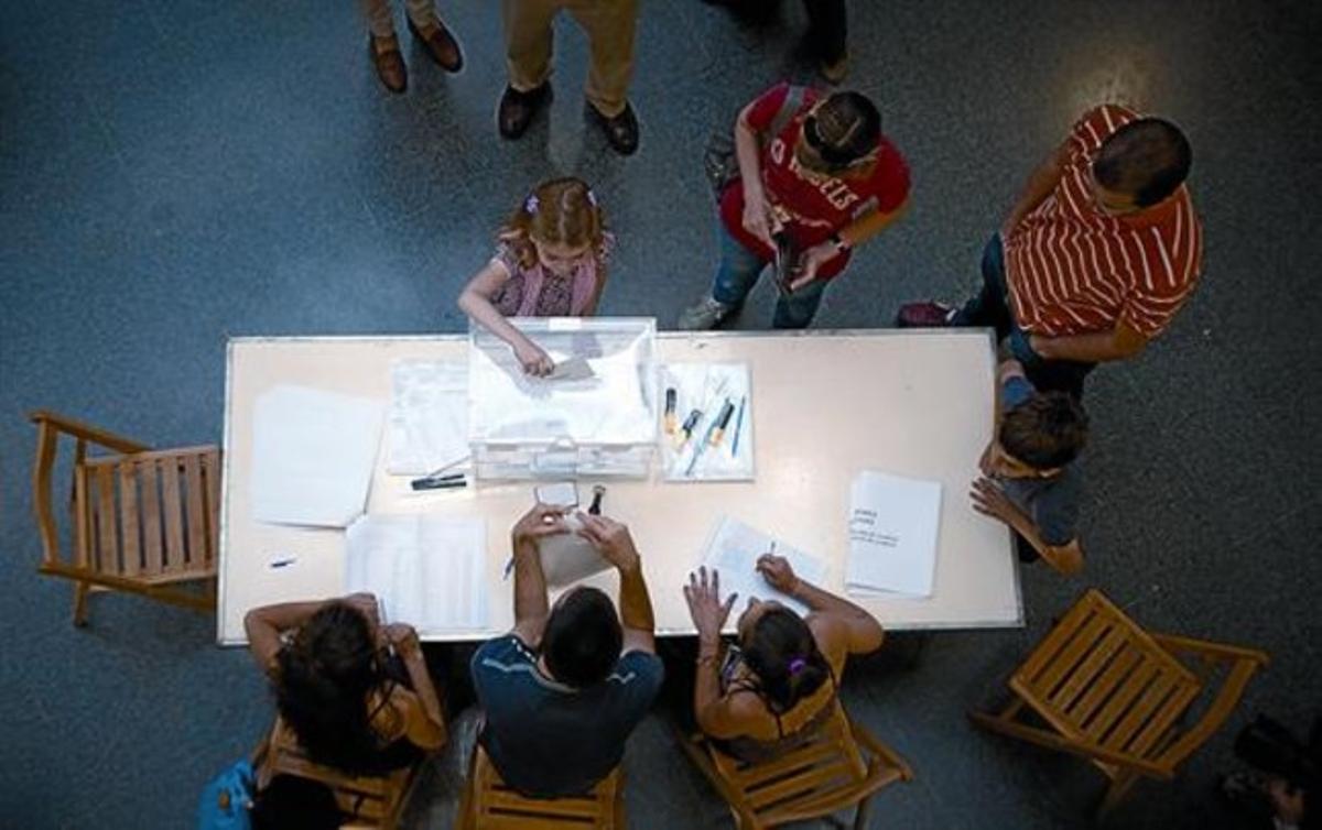 Una niña introduce en la urna el voto de su madre, el pasado 22 de mayo en el colegio Pau Romeva de Barcelona.