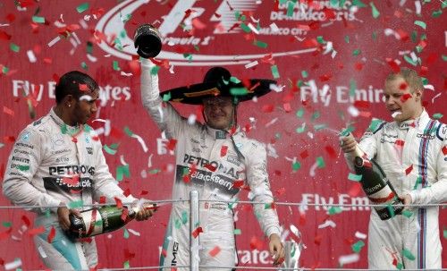 Mercedes Formula One driver Rosberg of Germany celebrates between his teammate Hamilton of Britain and Williams Formula One driver Bottas of Finland after winning the Mexican F1 Grand Prix at Autodromo Hermanos Rodriguez in Mexico City