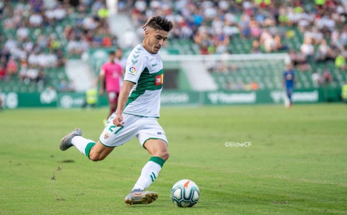 Óscar Gil centra un balón vistiendo la camiseta del Elche