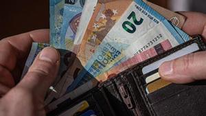 Un monedero con tarjetas y billetes de euros.