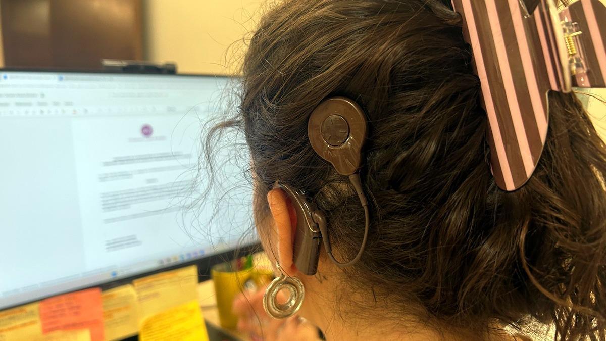 Paula González Rullas, en su puesto de trabajo, con el implante coclear.