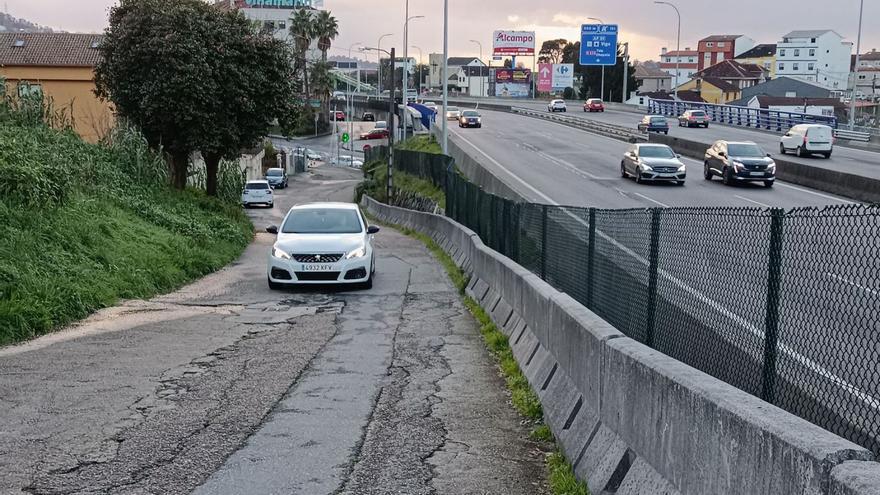 Un coche transita por el Camiño Mouriño de Chapela, ayer, con el firme en mal estado. // ANTONIO PINACHO