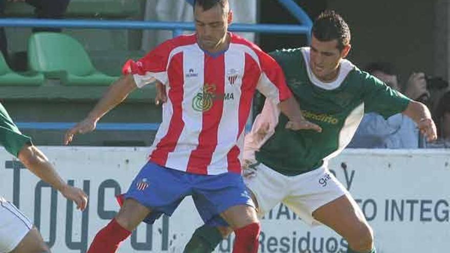 Un jugador del Coruxo trata de robar un balón durante un partido de Liga