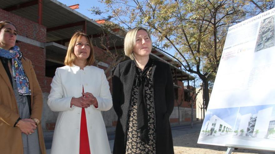 La consellera y la alcaldesa con el plano y el edificio al fondo