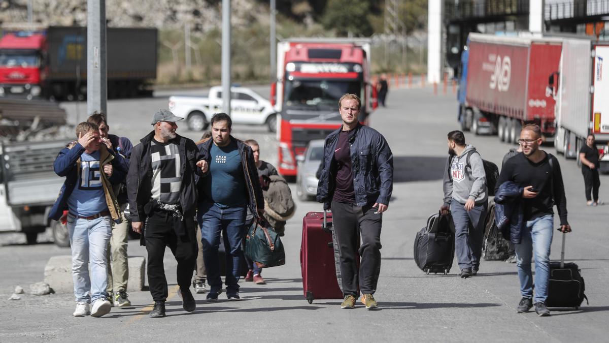 Verkhnii Lars (Georgia), 27/09/2022.- Russian men walk along a road after passing through customs at the Georgia-Russia border checkpoint of Verkhnii Lars, Georgia, 27 September 2022. Thousands of Russian men left Russia after Russian President Putin announced in a televised address to the nation on 21 September, that he signed a decree on partial mobilization in the Russian Federation due to the conflict in Ukraine. Russian Defense Minister Shoigu said that 300,000 people would be called up for service as part of the move. Georgian Interior Minister Vakhtang Gomelauri said on 27 September, that in recent days some 10,000 Russians have crossed the border with Georgia every day. On 24 February 2022 Russian troops entered the Ukrainian territory in what the Russian president declared a 'Special Military Operation', starting an armed conflict that has provoked destruction and a humanitarian crisis. (Rusia, Ucrania, Estados Unidos) EFE/EPA/ZURAB KURTSIKIDZE