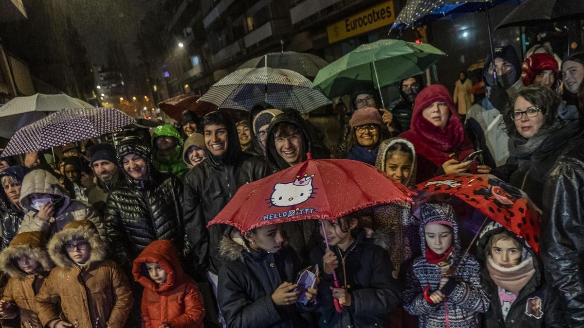 La gent gaudint de la Cavalcada de Reis, a Manresa, refugiada sota els seus paraigües