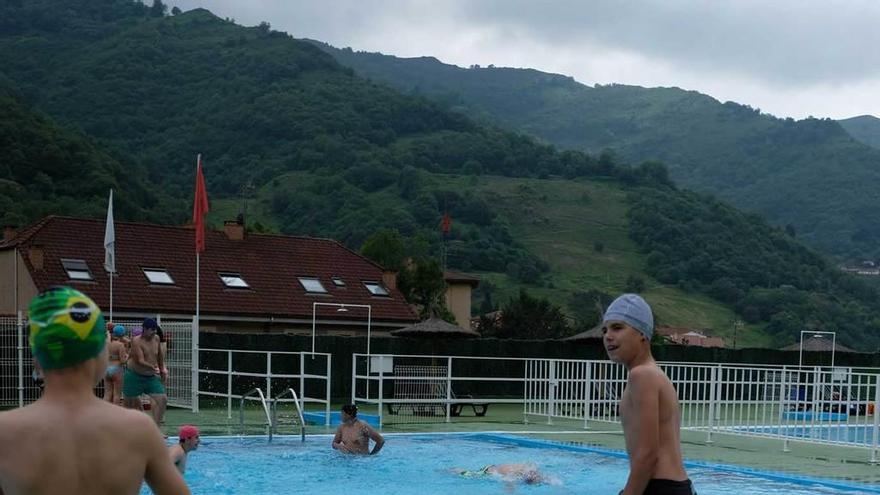 Varios niños disfrutan de un baño en la piscina de Turón.