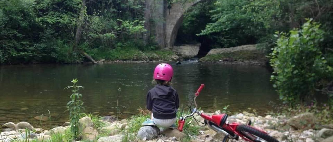 Una niña contempla el río La Marea desde la senda de La Peridiella.