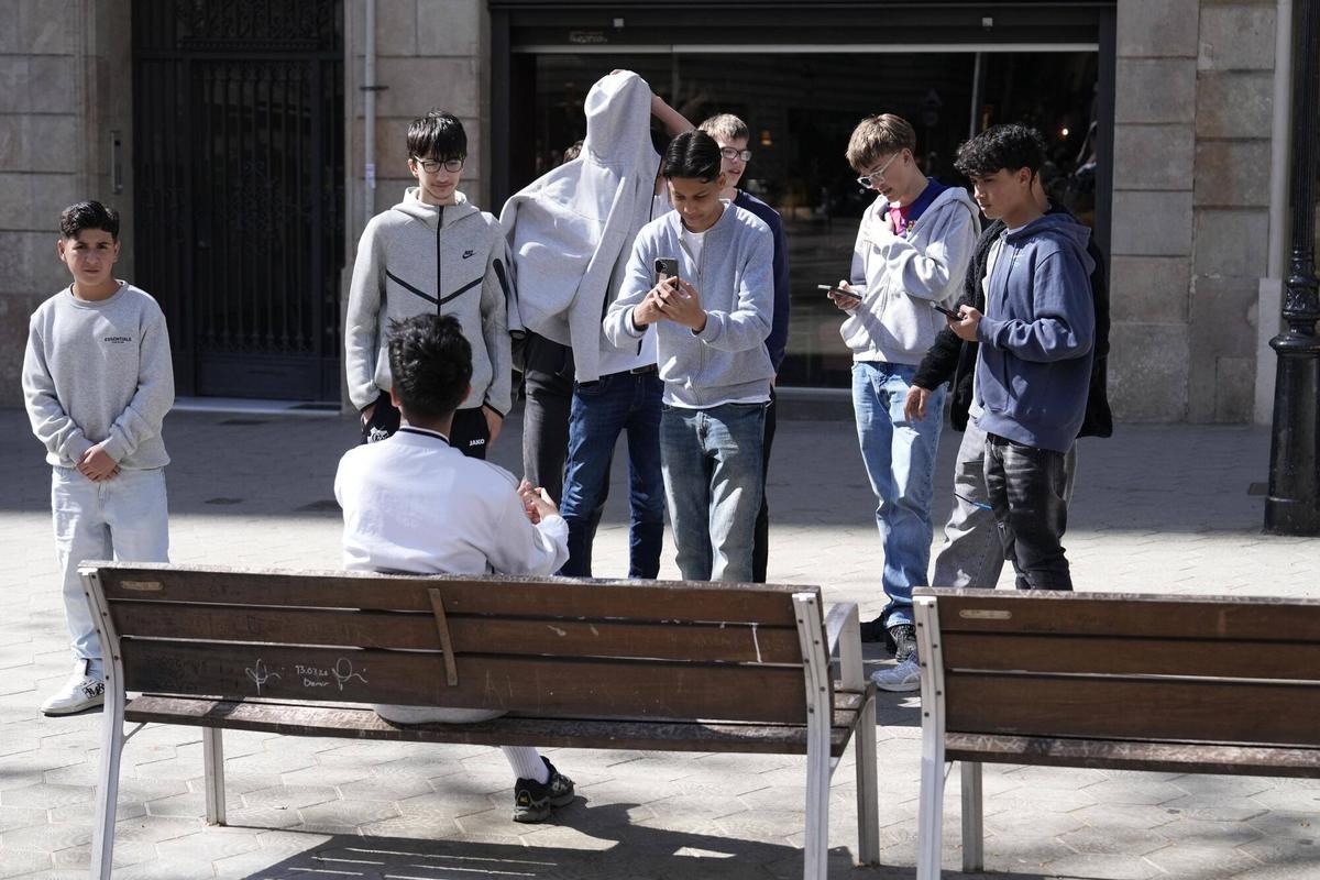 Tres turistes imiten la postura d’Arda Turan.