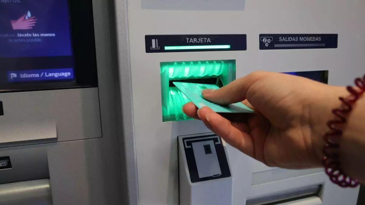Una mujer retira dinero de un cajero automático.