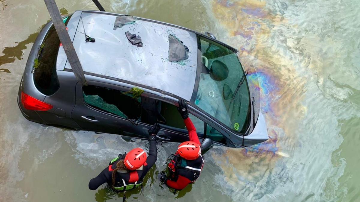 Bomberos de la DPZ extraen del canal el vehículo siniestrado.