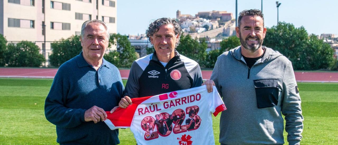 El vicepresidente Toni ‘Moreras’, Raúl Garrido, y Sergio Tortosa, director deportivo del CD Ibiza, posan con la camiseta que el club regaló al entrenador por su renovación.